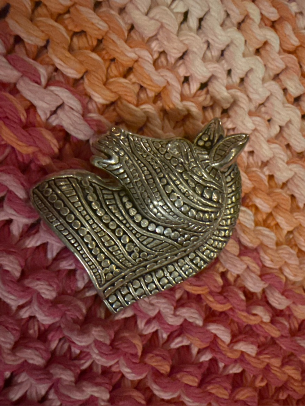 Decorative Silver-Tone Rhino Brooch on Pink-Orange Knit